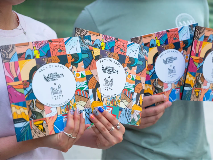 Hands holding three copies of ABCs of AAPI Coloring Book