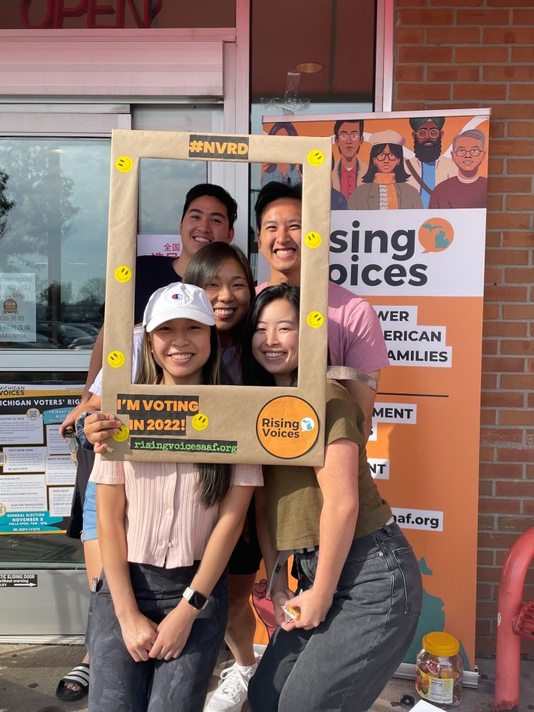 Group of people smiling at the camera with a "I'm voting together" sign